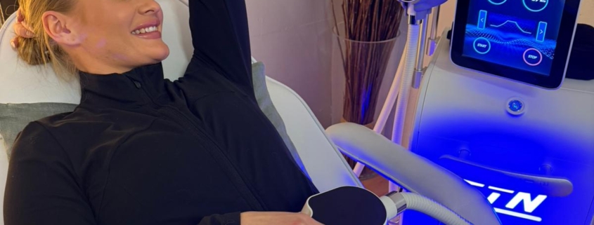 Nainen X-Tone lihasstimulaatiolaitteessa saa hoitoa vatsalihaksiin yhdellä hoitokahvalla.